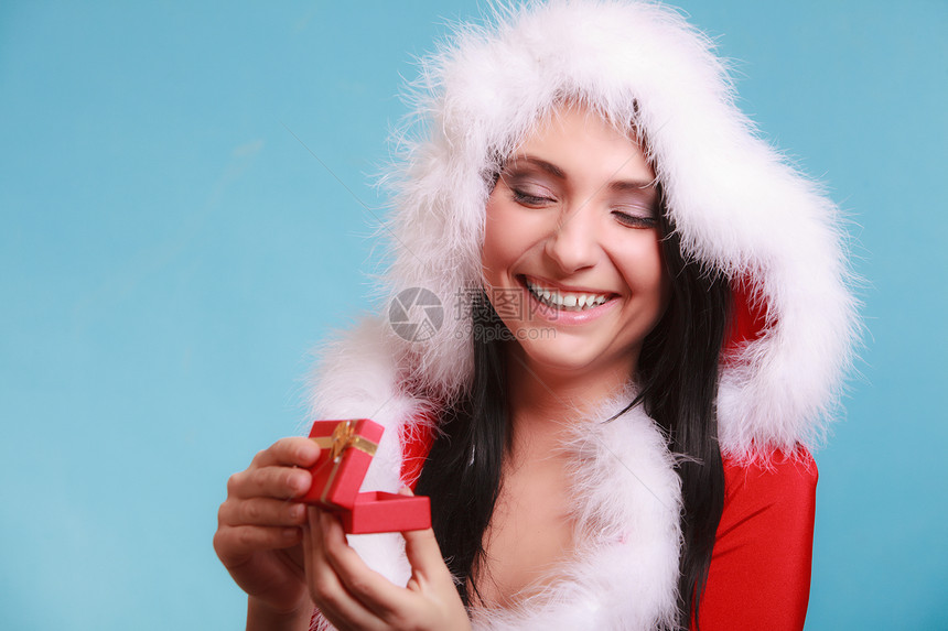 穿着圣达克萨斯服装的美女开着小红礼盒蓝底的金弓圣诞礼物图片