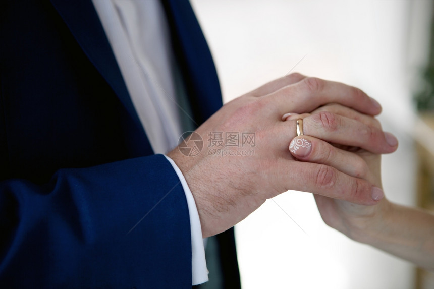 新娘的手和郎女人把结婚戒指在她的新郎手指上图片
