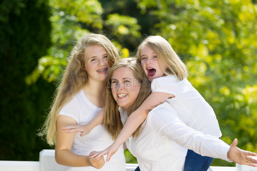 母亲抱着女儿和大抱她们而户外在院子里露天图片