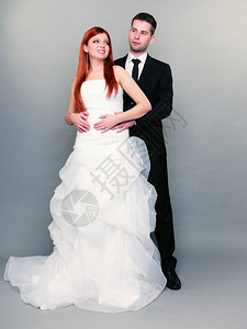 新郎和红发娘的肖像整个工作室里的新郎和红发娘灰色背景拍摄连衣裙高清图片素材