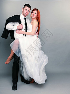 新郎和红发娘的肖像整个工作室里的新郎和红发娘灰色背景拍摄婚礼高清图片素材