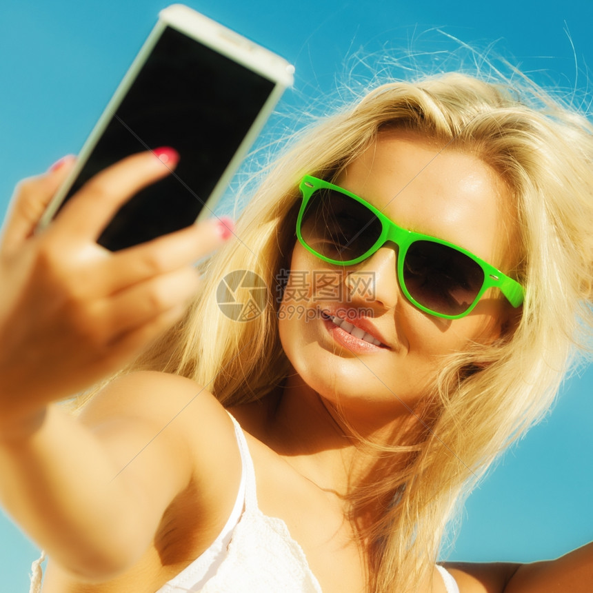 科技互联网旅游度假概念快乐的少女孩在海滩上用智能手机相自拍照图片
