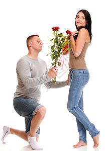 美丽的年轻快乐笑一对被孤立情侣爱肖像男人跪在膝下给他的女朋友一朵玫瑰而那个女孩则被孤立在白色上背景图片