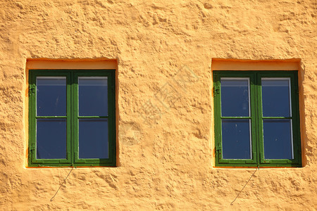 橙色墙壁背景房屋的绿色两扇窗图片