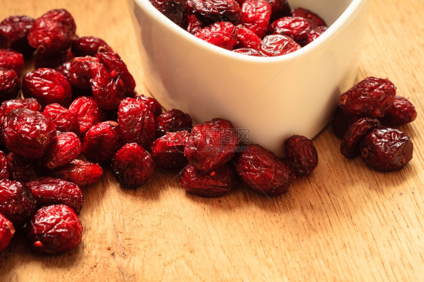 健康高纤维食品有机营养木制餐桌上的碗里闭干红莓果图片