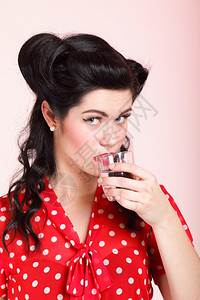 有针头化妆和发型的美少女饮用水粉红色背景背景图片
