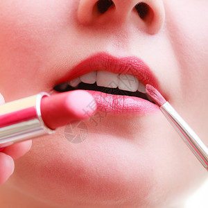 化妆美容程序和概念关闭部分妇女面对红唇化妆艺术家使用配饰工具涂口红背景图片