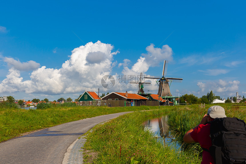 摄影师在荷兰河附近的ZaanseSchans拍摄风车照像的乡村景图片