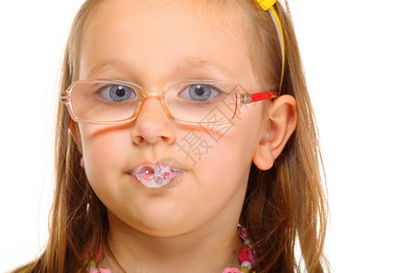 戴眼镜的有趣小女孩吐有趣的唾液泡图片