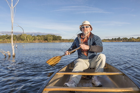 在科罗拉多州林斯堡河滨池塘自然区独木舟湖上享受晨日的老年男堡垒高清图片素材