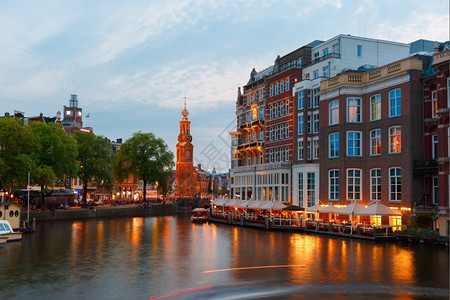荷兰阿姆斯特丹运河桥梁和蒙托伦塔的夜间城市景象高清图片