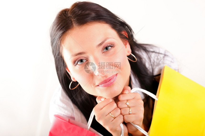 美丽的购物妇女快乐地拿着纸袋