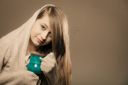 喝热饮沉睡的姑娘拿着一杯茶或咖啡穿着暖毛衣的女人自己暖身子早晨高清图片素材