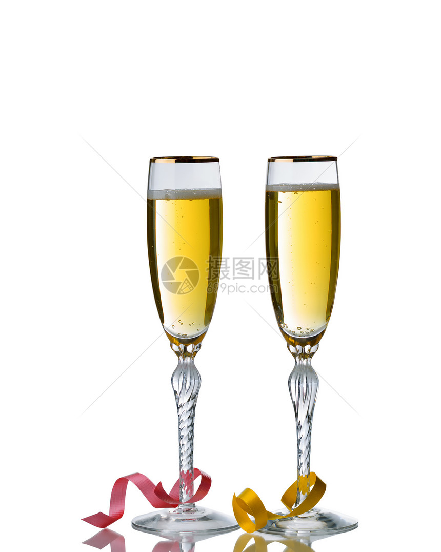 盛满金香槟的优美酒杯被白色背景隔绝反光和派对彩带图片