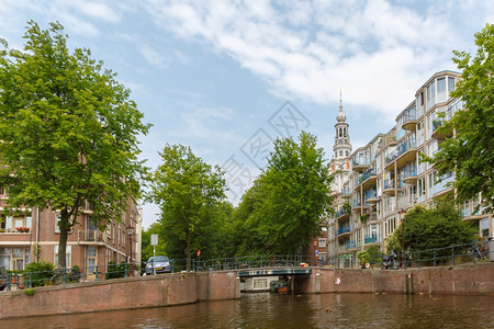 荷兰阿姆斯特丹运河教堂和典型房屋桥梁和自行车的城市景象图片