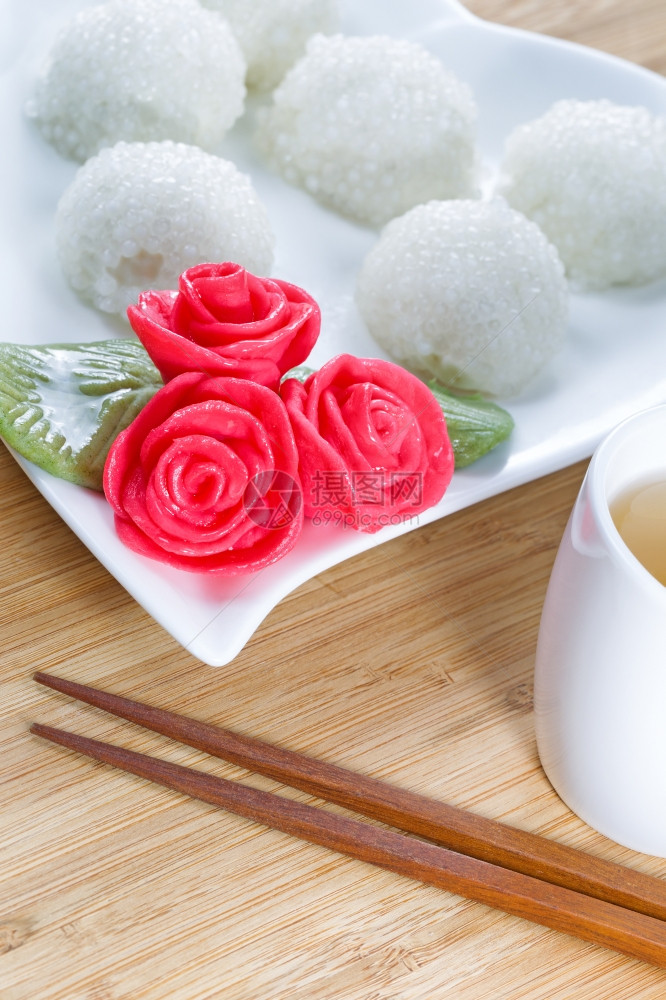 甜粘糊米球的垂直图像背景红装饰玫瑰和天然竹子绿茶图片