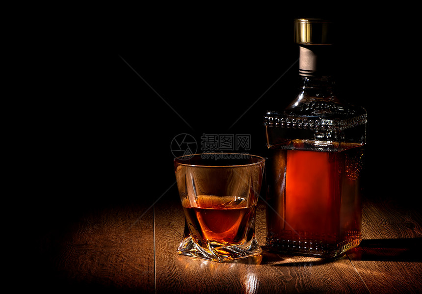 酒瓶和威士忌杯放在木制桌上图片