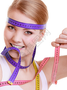 健康保生活方式运动适合身体健康的妇女头顶上有许多姿彩的测量磁带图片