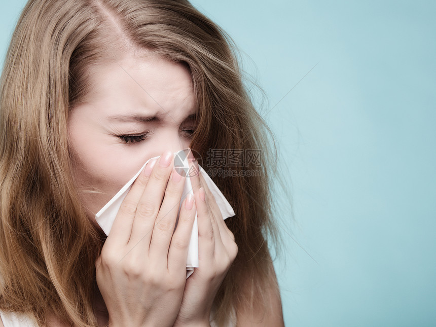流感或过敏症状生病的女人在蓝色组织里打喷嚏健康护理图片
