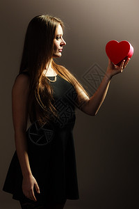 幸福情人节和爱概念美丽的优雅穿黑裙子色衣服灰红心形礼物盒的背景图片