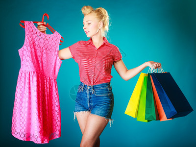 粉色衣服客户拿着鲜艳的纸袋蓝色零售和销工作室拍摄高清图片