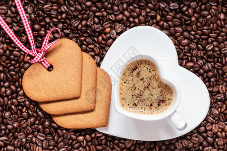 咖啡时间概念以咖啡豆背景的卡布奇诺莫咖啡和饼干姜的心形杯顶级视图图片