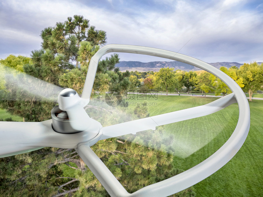 一架在公园上空飞行的小型无人驾驶直升机旋转图片