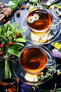 含蜂蜜的草药茶野生果子和木本的鲜花图片