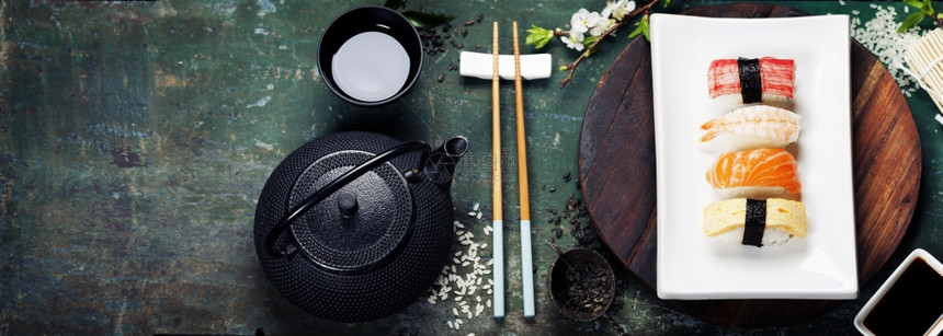 亚洲粮食背景黑铁茶和生锈桌上的寿司图片