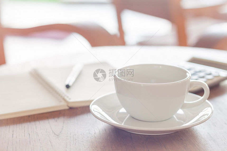 空白螺旋日记本边上放着茶杯图片