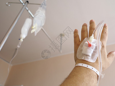医院里一个男病人的手臂静脉注射滴液背景图片