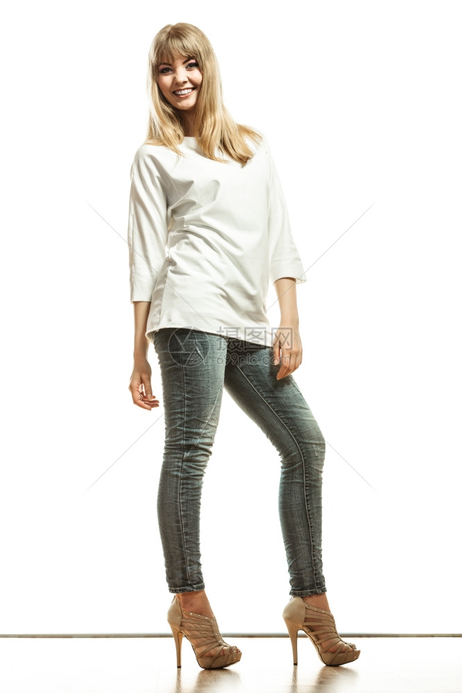 时装年轻金发年轻女子牛仔裤白蝙蝠袖高跟鞋完全孤立的女模特图片
