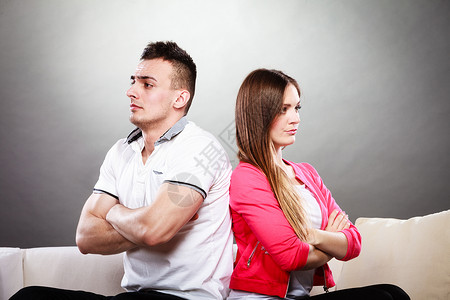 男人和女意见不一争吵后的年轻情侣坐在沙发上背对高清图片