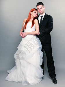 新郎和红发娘的肖像整个工作室里的新郎和红发娘灰色背景拍摄新娘高清图片素材