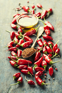 红辣椒和橄榄油覆盖木本底烹饪或辣食品概念图片