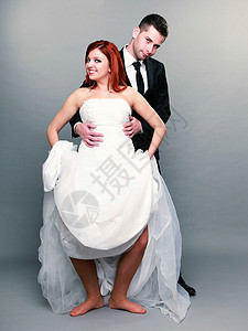 喜笑快乐的已婚夫妇肖像红发新娘和郎全长工作室的红发新娘和郎拍摄在灰色背景上女人高清图片素材