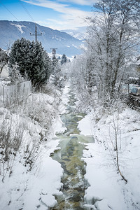 积雪覆盖的森林中快速山流美丽景观季节高清图片素材