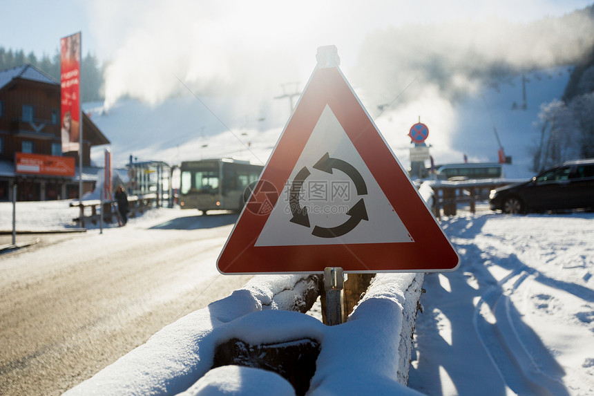 山上雪覆盖的公路上警示标志的紧贴照片图片