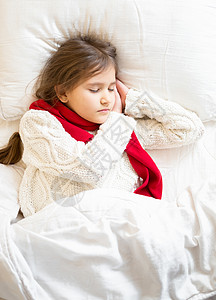 穿着毛衣和围巾的小女孩躺在床上睡觉图片