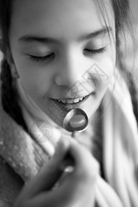 小女孩在勺子上吃药的黑白照片图片