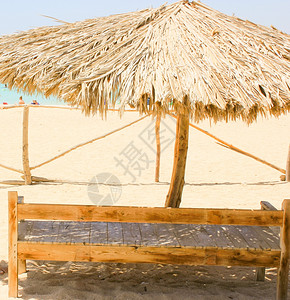 木椅子和自然保护伞在阳光之海滩上木椅子和自然保护伞图片