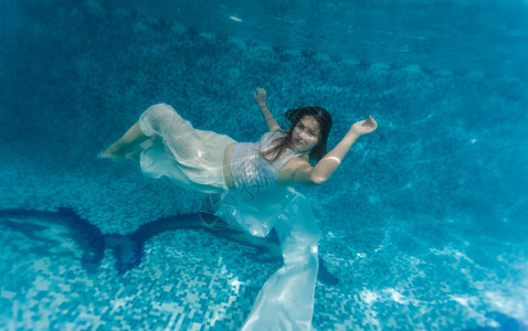 在水下游泳的白布女人下水镜头图片