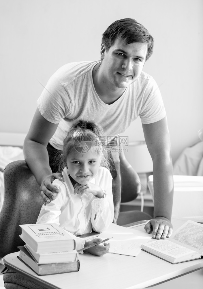 女儿在家和父亲一起做功课的黑白女儿肖像图片