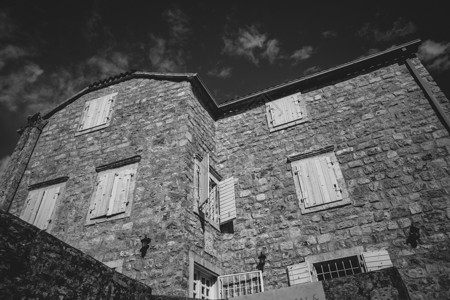 阳光明媚时旧石屋的黑白照片图片