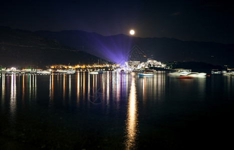 美丽的月亮景色在夜中照耀着海边城市图片