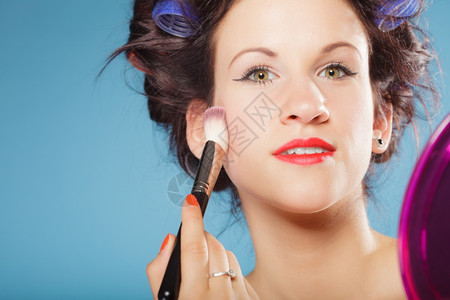 化妆美容程序和概念发卷的妇女用刷子化妆脸红女孩背景图片
