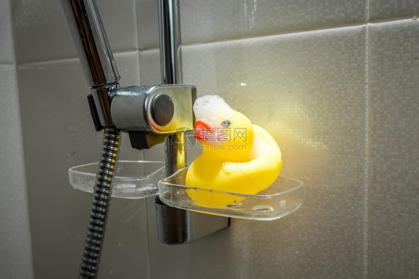 淋浴时被泡沫覆盖的黄橡胶鸭近照图片