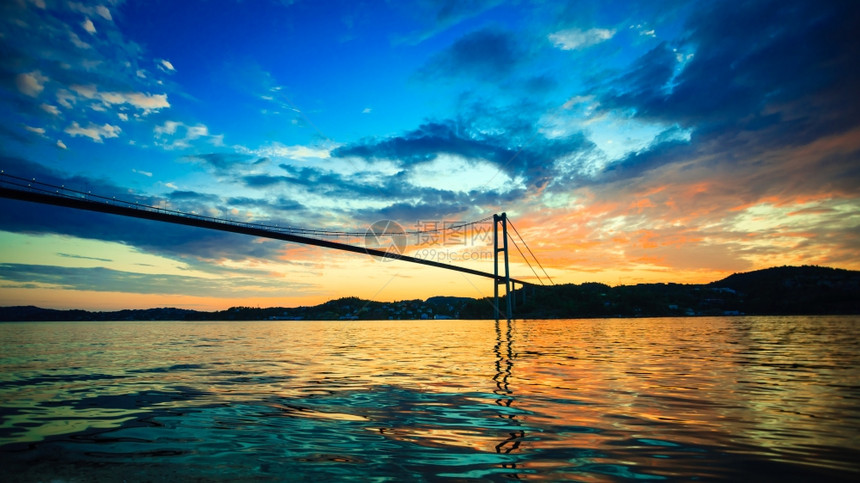 在挪威卑尔根的海面和长悬浮桥上有戏剧日落云层图片