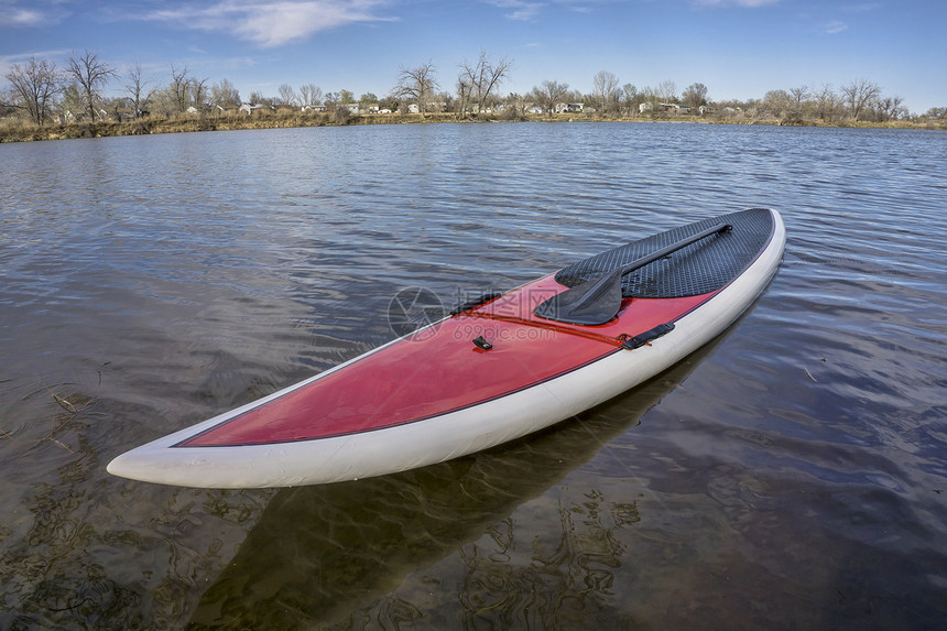 SUP红色的SUP板在湖岸的上有一个桨准备在科罗拉多州春季时间划船图片