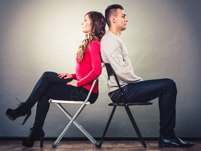 男女意见不一夫妻在争吵后坐椅子背对上误会高清图片素材